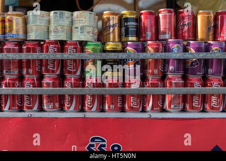 Le lattine di frizzanti bevande analcoliche impilati in righe. Kampot, Cambogia Foto Stock