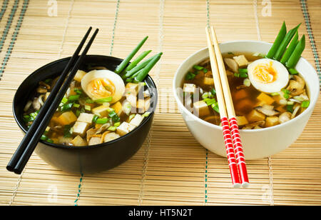 La zuppa di miso in ciotole sul tappetino di bambù Foto Stock