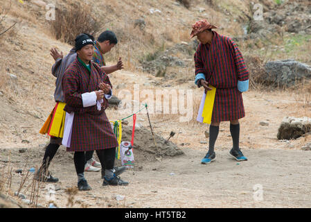 Il Bhutan, Paro. Khuru (freccette) tradizionale sport bhutanesi di lanciare freccette di grandi dimensioni all'aperto, dart in target. I giocatori in costumi tradizionali. Foto Stock