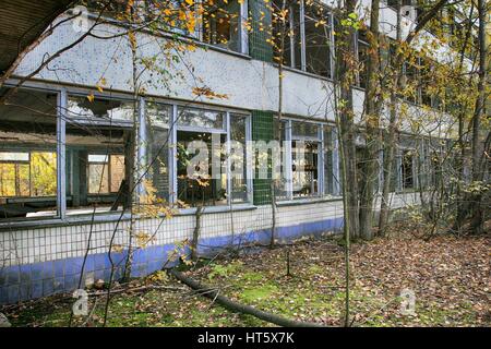 Cernobyl: pripjat - edificio abbandonato preso in consegna dalla vegetazione dopo il disastro Foto Stock