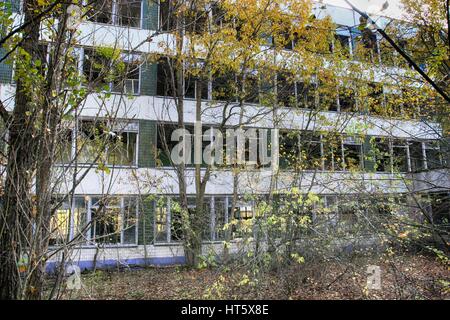 Cernobyl: pripjat - edificio abbandonato preso in consegna dalla vegetazione dopo il disastro Foto Stock