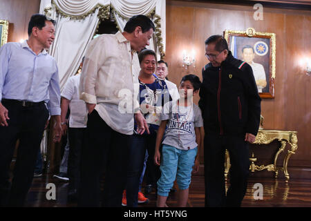 Il presidente filippino Rodrigo Duterte colloqui con rapire vittima Rexon Romoc dopo il ricongiungimento con i suoi genitori Nora e Elmer presso il palazzo di Malacanang Febbraio 28, 2017 a Manila nelle Filippine. Il ragazzo è stato rapito dai membri del gruppo Abu Sayyaf lo scorso 5 Agosto, 2016. In piedi con il presidente sono da sinistra a destra sono: Sulu Vicegovernatore Sakur Tan, assistente speciale al presidente Christopher Lawrence andare, e il consigliere presidenziale sul processo di pace Gesù Dureza. Foto Stock