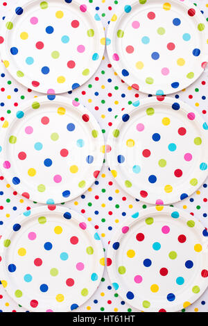 Colorato pois piastre di carta su una polka dot tovaglia. Pattern Foto Stock