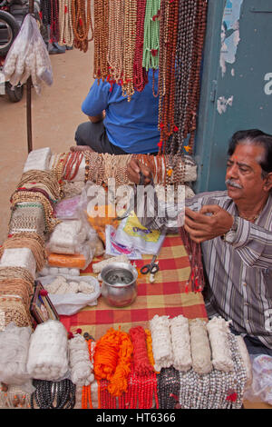 Street trader stringhe di vendita dei grani di preghiera (Japa mala), da utilizzare per realizzare le dediche, nei pressi di un tempio indù in Badi Chaupar distretto di Jaipur Foto Stock