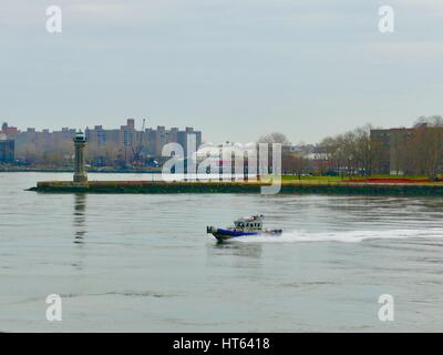 Pattuglia di NYPD crociere in barca fino l'East River in una piovosa, fine giornata invernale. New York, New York, Stati Uniti d'America. Foto Stock