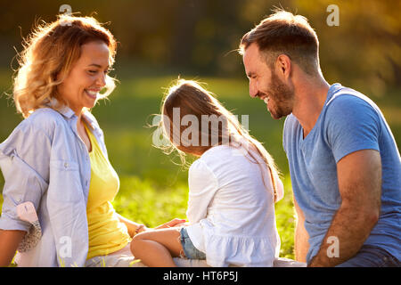 La ragazza con i genitori di passare del tempo libero outdoor Foto Stock