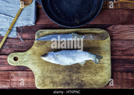 Il pesce congelato puzzava sulla scheda di cucina, vista dall'alto Foto Stock