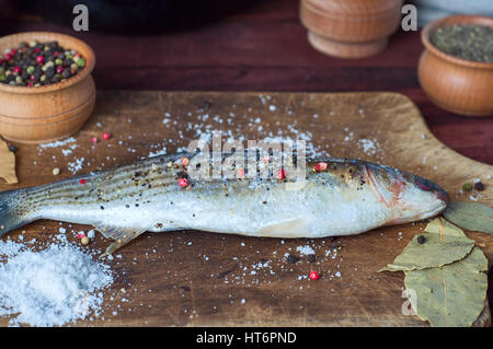 Profumava di fresco pesce in spezie per cucinare su una scheda di cucina, macro Foto Stock