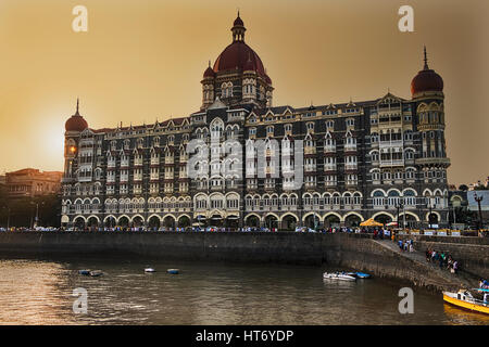 Una vista del Taj Palace al tramonto guardando sopra la parte del porto di fronte al lungomare di Mumbai, India. Foto Stock