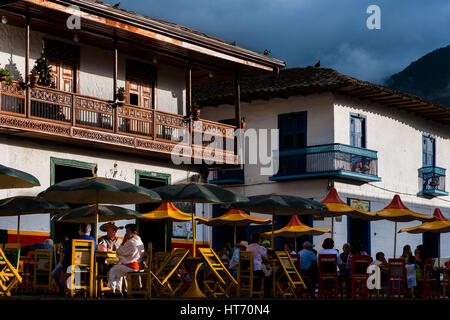 Contadini colombiani sedervi in una caffetteria di fronte le case coloniali presso la piazza principale di jardín, un villaggio nella regione di caffè in Colombia. Foto Stock