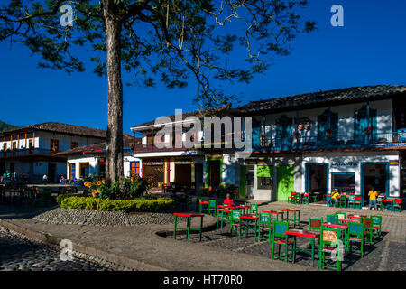 Contadini colombiani sedervi in una caffetteria di fronte le case coloniali presso la piazza principale di jardín, un villaggio nella regione di caffè della Colombia. Foto Stock