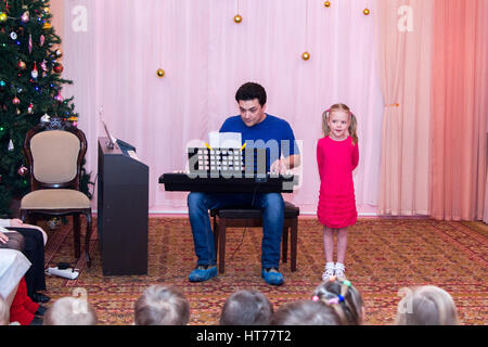 Ragazza canta mentre suo padre suona il sintetizzatore Foto Stock