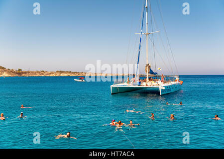 Catamarano caricato con i turisti con il blu del cielo e acqua azzurra su sfondo Foto Stock