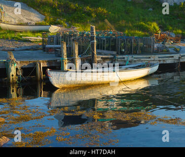 Il golden ora luce della sera cade su una barca a remi in Peggy's Cove, Nova Scotia, Canada Foto Stock