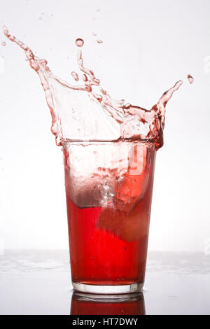 Splash di fresco drink rosso su sfondo bianco Foto Stock