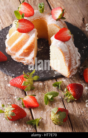 Fette di ciambellone con menta fresca e fragole da vicino sul piano verticale. Foto Stock