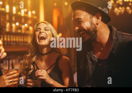 Gruppo di persone nel pub avendo divertimento. Giovani amici godendo di una notte nel club. Foto Stock