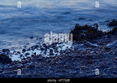 Il mare a Clevedon nel Somerset, Regno Unito, prese con un lento rilascio otturatore dando il mare un effetto seta sulle rocce Foto Stock