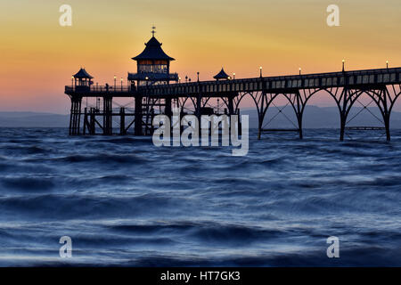 Tramonto a Clevedon Pier nel Somerset, Regno Unito prese con un lento rilascio otturatore dando il mare un effetto seta. Foto Stock