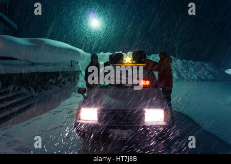 Snowboarder ingranaggio di scarico dalla parte superiore del Taxi Auto In Asahidake, Giappone Foto Stock