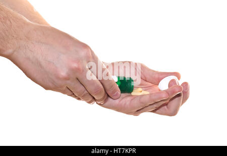 Pillole in mano isolati su sfondo bianco. Pills versare dal flacone verde su sfondo bianco. Una buona medicina dello sfondo. Foto Stock