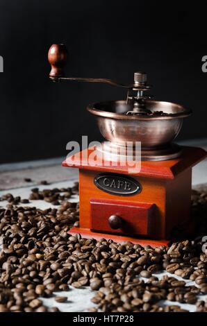 Retrò vecchio macinino da caffè su sfondo di legno con chicchi di caffè tostati Foto Stock