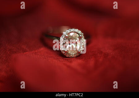 Anello di diamante su sfondo rosso Foto Stock