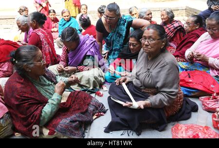 Kathmandu, Nepal. 8 Mar, 2017. Sheela Sayami, un lavoratore sociale (C) incarica i superstiti del terremoto e i cittadini anziani di preparare il filo lampade per relgious preghiere, sulla Giornata internazionale della donna a Kathmandu, Nepal. Sheela Sayami, un lavoratore sociale corre un non remunerative di organizzazione denominata ''Nhapangu Pala (primo passo in lingua Newari) che si impegna con le vittime del terremoto nel racconto e attività creative come la preparazione di lampade di filettatura. Più di 60 cittadini anziani di età compresa tra 70 a 96 anni di raccogliere tutti i giorni di condividere i loro sentimenti e si impegnano in diverse attività sotto l'iniziativa di Foto Stock