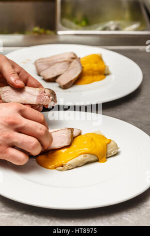 Maschio di cuochi preparare i pasti nel ristorante cucina Foto Stock