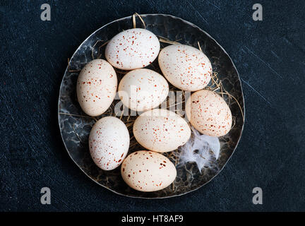 Il pollo crudo uova sulla piastra e su una tavola Foto Stock