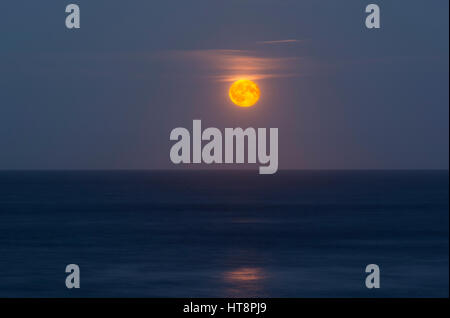 Full Moon Rising oltre il mare al largo della costa di Northumberland Foto Stock