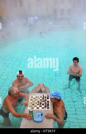 Le persone giocano a scacchi all'Széchenyi Bagno di medicinali nel parco cittadino (Varosliget) Budapest, Ungheria. È il più grande bagno termale in Europa Foto Stock