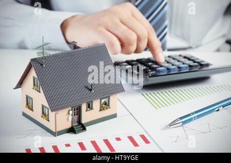 Imprenditore calcolare il costo per la costruzione e il mantenimento di casa. Home concezione delle finanze Foto Stock