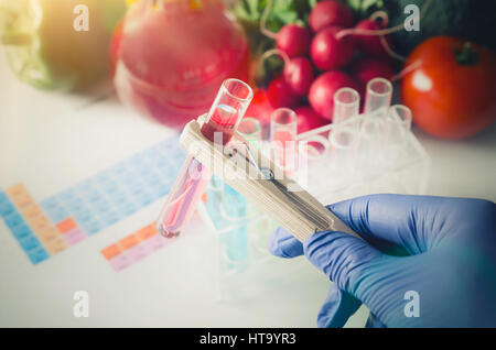 Ogm alimenti geneticamente modificati in lab concept. Analista di guanti prende il tubo di prova. Foto Stock