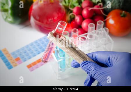 Analista di guanti prende il tubo di prova. Alimenti geneticamente modificati in lab concept. Foto Stock