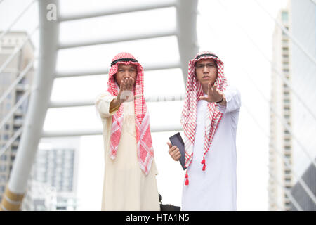 Due Arabian uomo facendo fermare un gesto con la mano alzata che indica un arresto (selettivo focalizzato) Foto Stock
