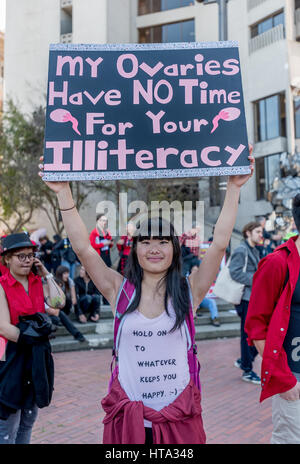 San Francisco, Stati Uniti d'America. 8 Mar, 2017. Una donna che tiene un segno di protesta di lettura, 'My ovaie non hanno tempo per l' analfabetismo a San Francisco la Giornata internazionale della donna rally appena prima del marzo da Justin Herman Plaza. Credito: Shelly Rivoli/Alamy Live News Foto Stock