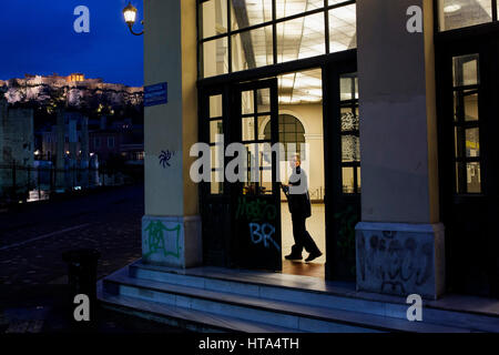 Una donna delle pulizie pulisce l'ingresso della stazione metropolitana la mattina presto ad Atene in data 6 marzo 2017. Foto: Angelos Tzortzinis/dpa Foto Stock