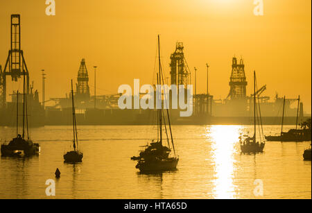 Las Palmas de Gran Canaria, Isole Canarie, Spagna. Il 9 marzo 2017. Meteo: un glorioso sunrise a Las Palmas la città come pre alba foschia marina brucia fuori e caldo venti da sud portare maggiori rispetto alle normali temperature di marzo (31 gradi Celcius ieri). Questi hot venti da sud sta alimentando aria più calda come lontano nord come il Regno Unito. Nella foto: impianti di trivellazione del petrolio e di navi da perforazione in Las Palmas porta come il sole sorge sull'Oceano Atlantico. Credito: ALAN DAWSON/Alamy Live News Foto Stock