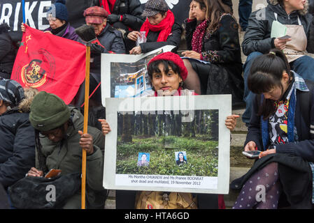 Londra, Regno Unito. 8 marzo 2017. Una donna che tiene un poster di due donne assassinate gli agricoltori alla veglia silenziosa sui passi di San Martin-in-the-Fields da Sciopero Globale delle Donne, l'sulla Giornata internazionale della donna in solidarietà con gli agricoltori di Thailandia, molti di loro donne, nel sud federazione contadina della Tailandia e per gli altri a rischiare la propria vita per difendere la terra e l'acqua dai terreni aziendali in palio. Credito: Peter Marshall / Alamy Live News Foto Stock