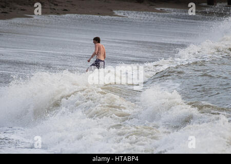 Aberystwyth, Wales, Regno Unito. 9 Marzo, 2017. Regno Unito Meteo: un giovane intrepido uomo nuoto nelle onde del mare increspato a Aberystwyth alla fine di una calda giornata di primavera, con tempertatures raggiungendo la bassa teens centigradi Photo credit: Keith Morris/Alamy Live News Foto Stock