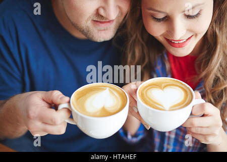 Coppia giovane di bere il cappuccino da tazze in porcellana Foto Stock