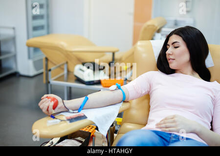 Giovane donna dando il suo sangue nel centro hemotransfusion Foto Stock
