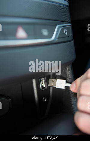 Stretta di mano che trattiene il connettore USB in auto Foto Stock
