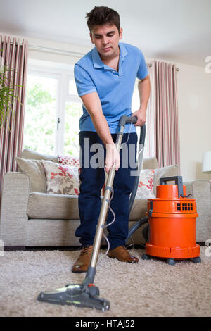 Giovane uomo professionalmente pulizia di tappeti Foto Stock