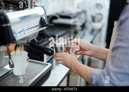 Barista la preparazione della schiuma di latte per il cappuccino Foto Stock