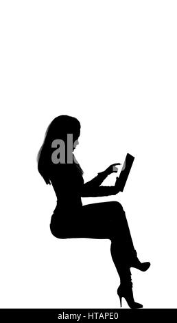 Donne ubicazione sul fronte posteriore cercando il suo tablet. Capelli lunghi, montare, tacco alto. Stephanie Foto Stock