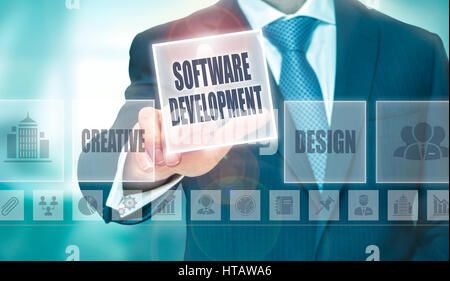 Un imprenditore premendo un Software Development pulsante su uno schermo trasparente. Foto Stock