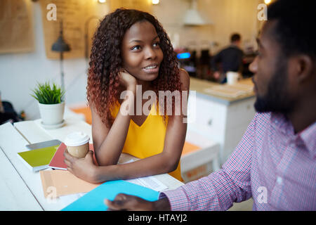 Ragazza il brainstorming durante la discussione delle nuove tendenze del design con uomo Foto Stock