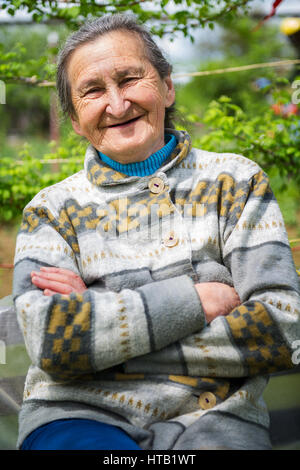 Bella 80 plus anno vecchia donna senior in posa per un ritratto nel suo giardino. Foto Stock